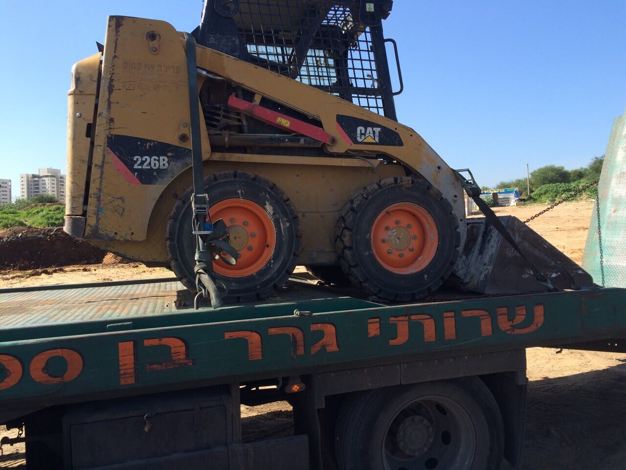 בובקט מועמס על משאית גרר בן
